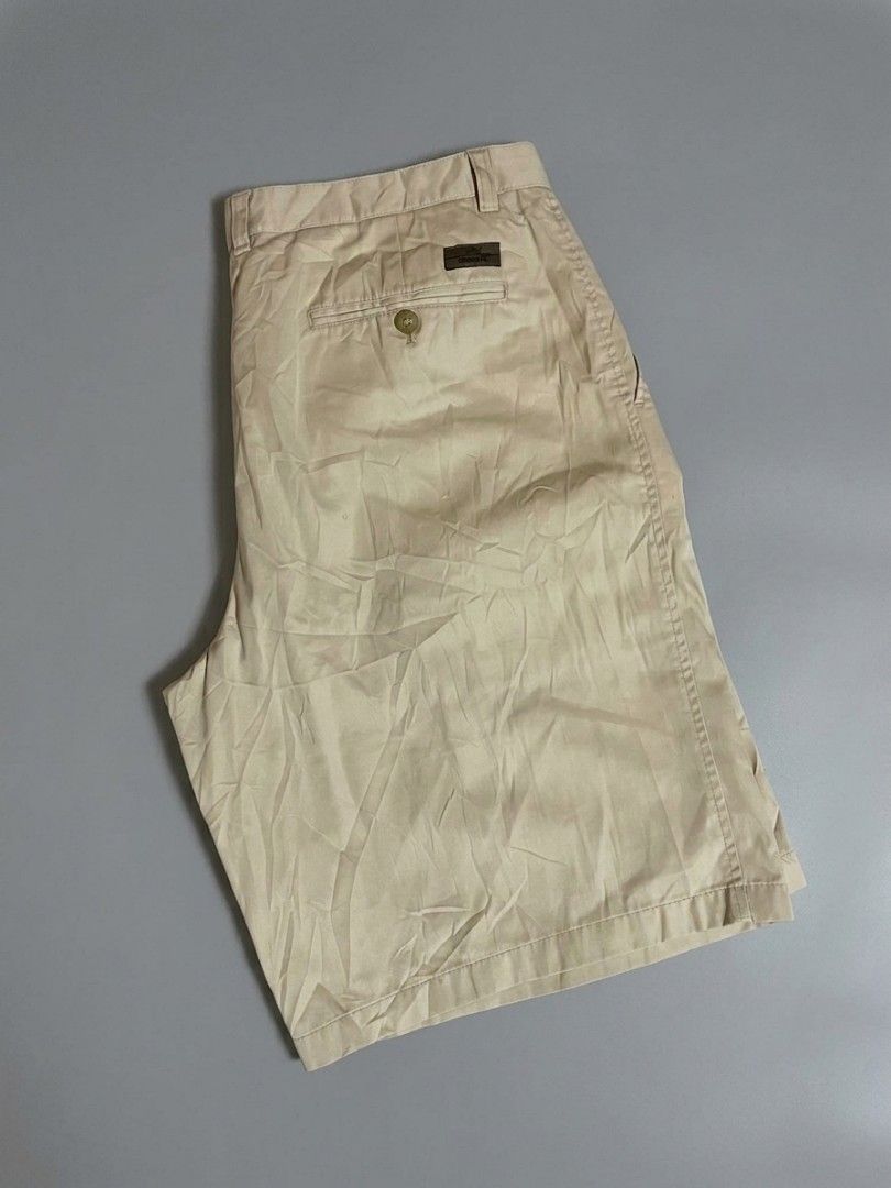 Lacoste Beige Pleated Chino Shorts (Category: Shorts) located in Manila. Submitted by gentlefalcon.29dc69 (Listing ID 1456752714, Image 2). Description: - Beige Lacoste shorts - Classic pleated style - Iconic crocodile logo on waistband - Small brown tag on back pocket - Versatile for casual or smart-casual looks - Comfortable fit.