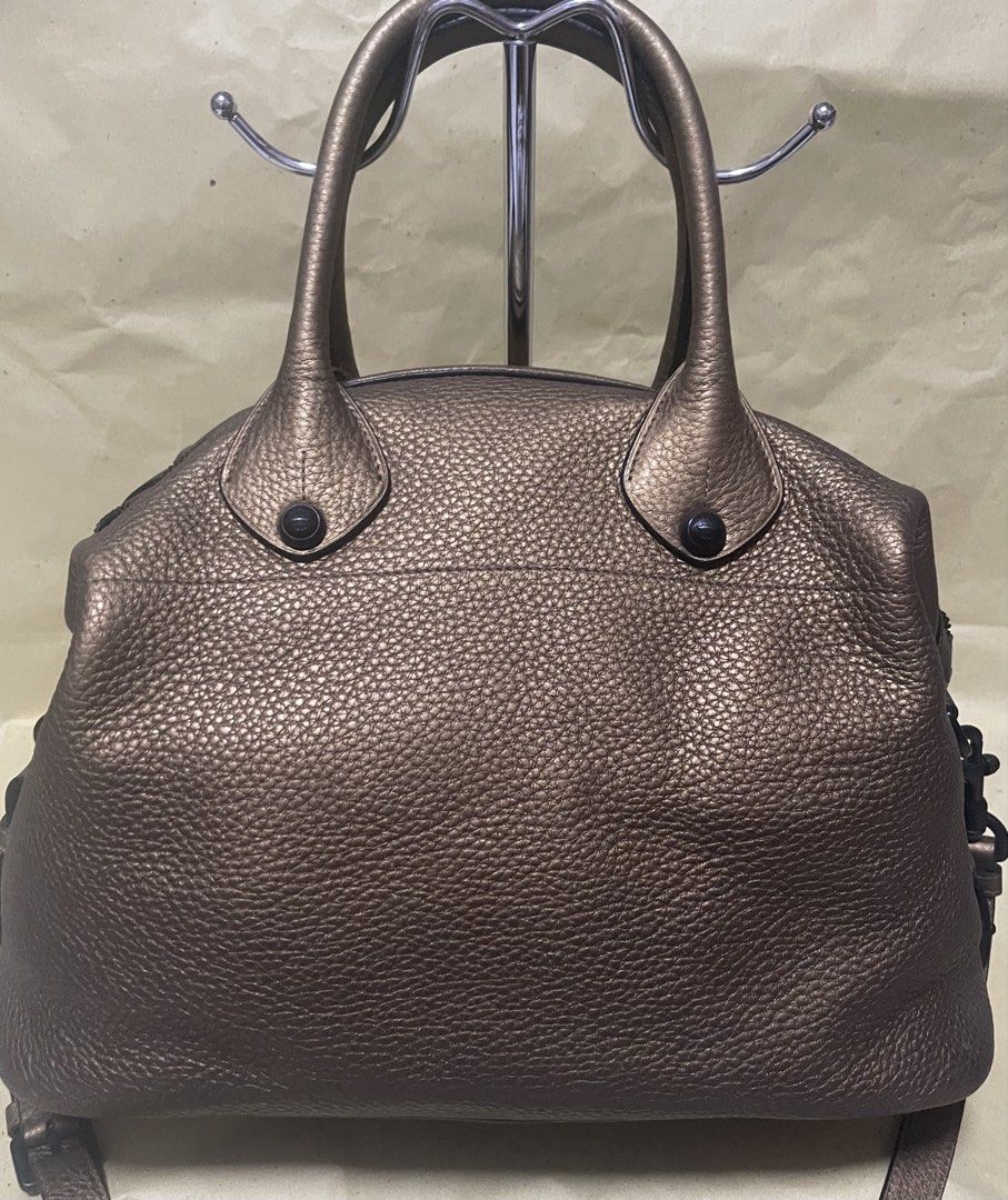 Loewe Metallic Gold Leather Satchel Bag (Category: Luxury Bags & Wallets) located in Manila. Submitted by ermenchita71969 (Listing ID 1456736722, Image 2). Description: - Authentic Loewe satchel bag in metallic gold leather. - Textured pebbled leather finish. - Front flap pocket with black leather accent. - Top zipper closure with embossed Loewe logo zipper pull. - Interior tag: Loewe Madrid 1846. - Includes a detachable shoulder strap..