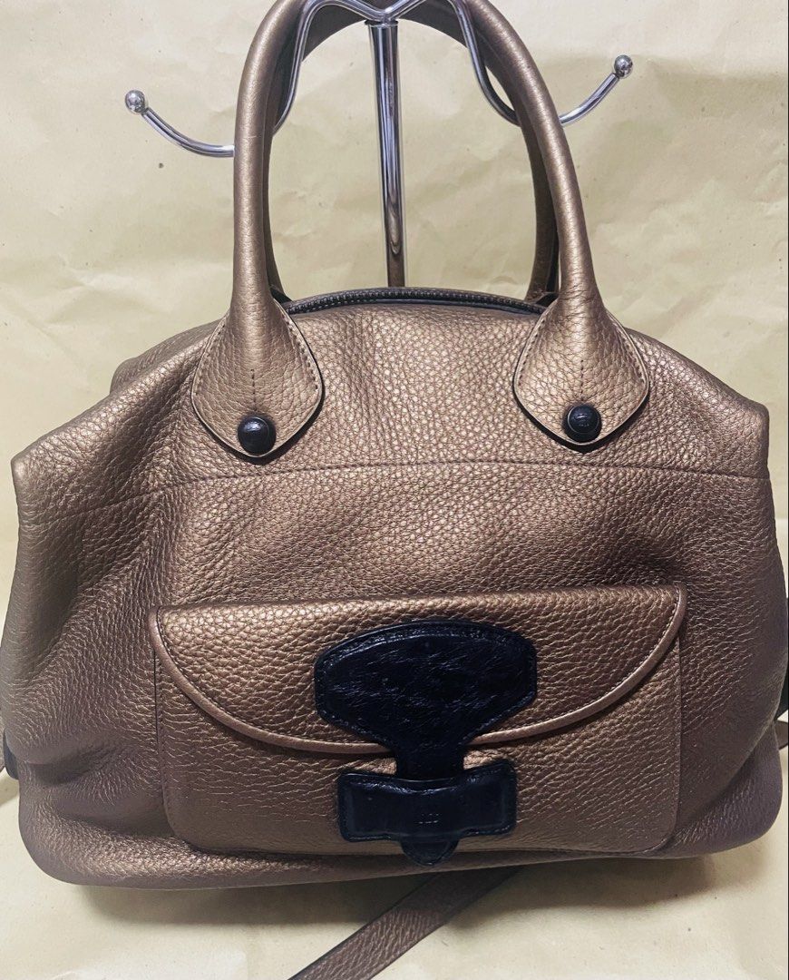Loewe Metallic Gold Leather Satchel Bag (Category: Luxury Bags & Wallets) located in Manila. Submitted by ermenchita71969 (Listing ID 1456736722, Image 1). Description: - Authentic Loewe satchel bag in metallic gold leather. - Textured pebbled leather finish. - Front flap pocket with black leather accent. - Top zipper closure with embossed Loewe logo zipper pull. - Interior tag: Loewe Madrid 1846. - Includes a detachable shoulder strap..