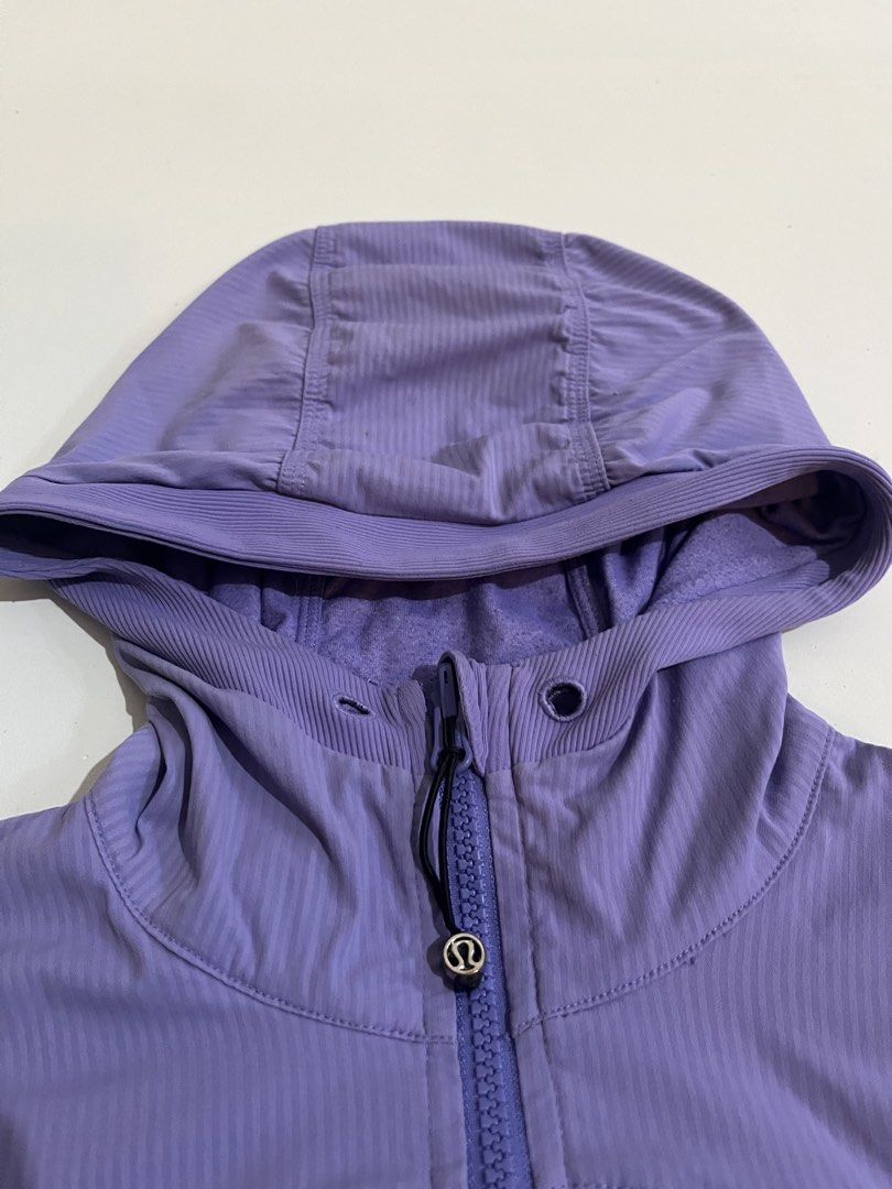 Lululemon Purple Striped Hooded Jacket Size 4 (Category: Coats, Jackets and Outerwear) located in Aloran. Submitted by alrodferna18731 (Listing ID 1456671154, Image 3). Description: - Lululemon jacket in purple - Size 4 - Hooded design - Features a stylish striped pattern on body and sleeves - Ruched detailing on front and sleeves for a flattering fit - Convenient thumbholes on cuffs - Two functional front pockets.