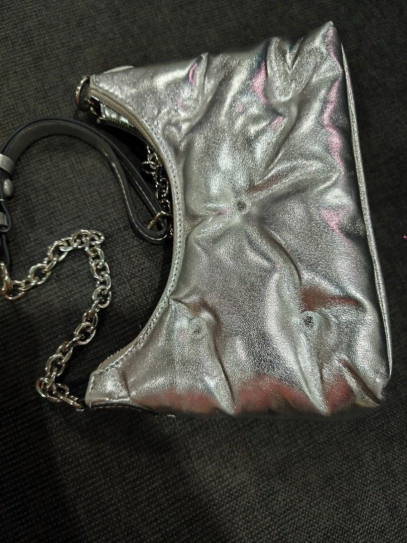 Maison Margiela Silver Glam Slam Shoulder Bag (Category: Luxury Bags & Wallets) located in Bay. Submitted by silverhorse-59c851 (Listing ID 1456778448, Image 3). Description: - Puffy, padded silver metallic shoulder bag - Silver chain strap - Zipper closure - Iconic Maison Margiela number tag - Great statement piece - Fits essentials.