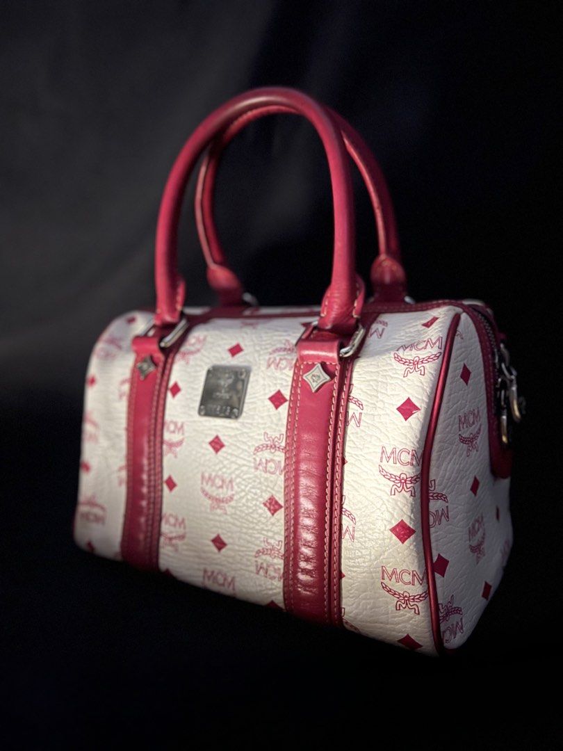 MCM Monogram Boston Bag with Pink Leather Trim (Category: Luxury Bags & Wallets) located in Las Pinas. Submitted by lyrehs1981 (Listing ID 1456658123, Image 3). Description: - Classic MCM Boston bag - Color: White with pink MCM monogram print - Trim and handles: Pink leather - Hardware: Silver-tone - Closure: Zipper - Ideal for everyday use or travel Minimal sign of usage.