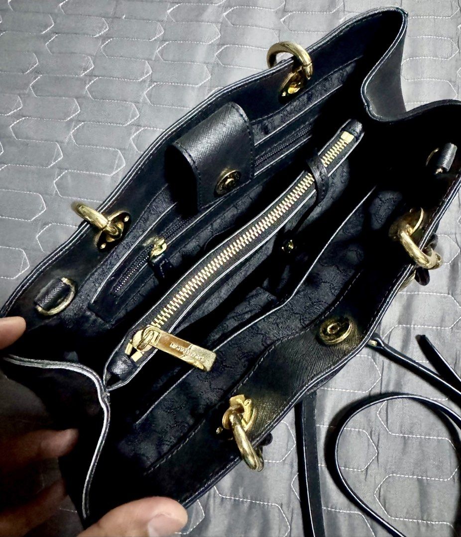 Michael Kors Black Leather Bag with Gold Hardware (Category: Luxury Bags & Wallets) located in Manila. Submitted by jonn1 (Listing ID 1456644681, Image 3). Description: - Genuine black leather Michael Kors tote bag - Elegant gold chain detail on handles - Comes with a detachable shoulder strap for versatility - Features multiple interior compartments and a secure zip pocket - Adorned with a signature MK logo charm - Ideal for everyday style and f