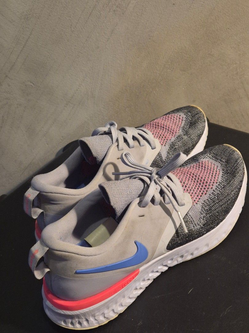 Nike Epic React Flyknit Running Shoes (Category: Sneakers) located in Manila. Submitted by rzzb21 (Listing ID 1456652136, Image 2). Description: - Nike Epic React Flyknit running shoes - Grey knit upper with pink accents - Blue swoosh on the side - Bright pink heel counter - Soles show wear but have good tread remaining - Suitable for running or casual wear -Size 6.5 wmns or 23.5cm.