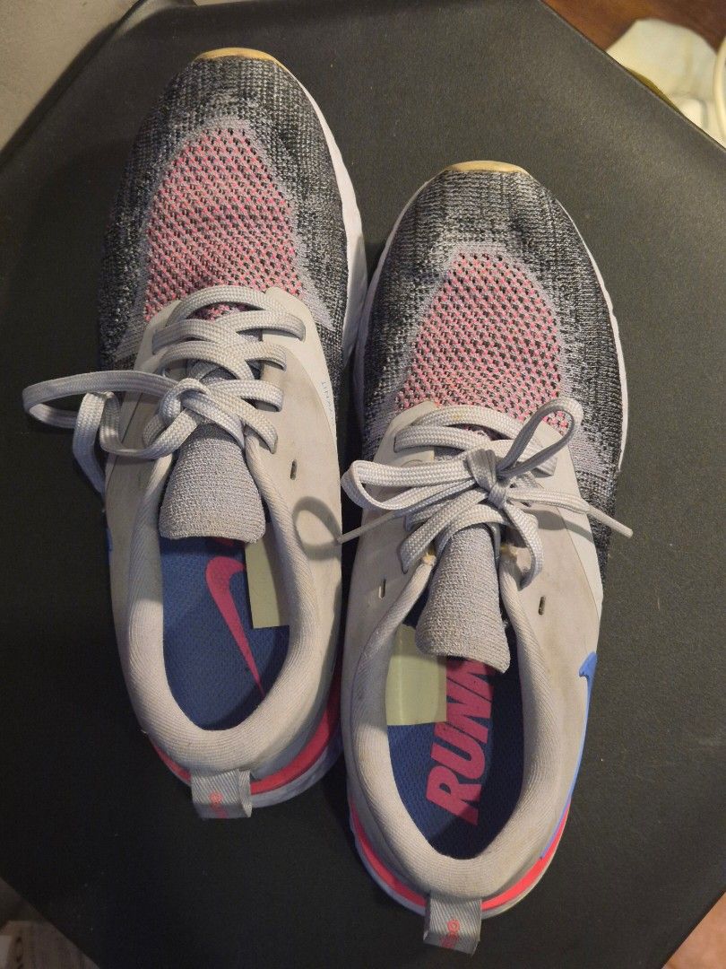 Nike Epic React Flyknit Running Shoes (Category: Sneakers) located in Manila. Submitted by rzzb21 (Listing ID 1456652136, Image 3). Description: - Nike Epic React Flyknit running shoes - Grey knit upper with pink accents - Blue swoosh on the side - Bright pink heel counter - Soles show wear but have good tread remaining - Suitable for running or casual wear -Size 6.5 wmns or 23.5cm.