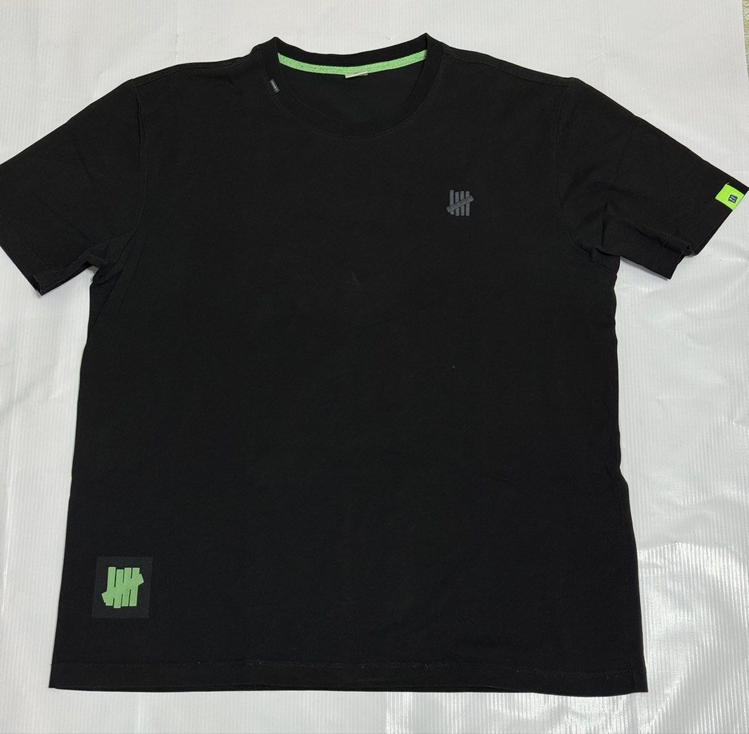 Random Brand Black T-shirt with Logo (Category: Tshirts & Polo Shirts ) located in Quezon City. Submitted by domsselections2 (Listing ID 1456763853, Image 1). Description: - Brand: Random - Color: Black - Features: Classic Undefeated logo on chest and sleeve - Detail: Subtle green trim on neckline - Occasion: Casual wear Dimes: 22x27”.