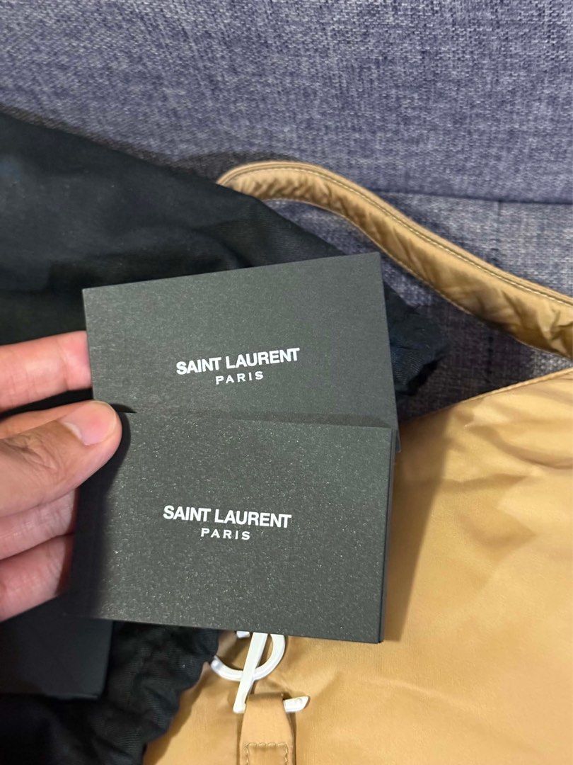 Saint Laurent Paris Nylon Shoulder Bag (Category: Luxury Bags & Wallets) located in Paranaque City. Submitted by piasacramento (Listing ID 1456633648, Image 2). Description: - Authentic Saint Laurent Paris shoulder bag - Tan nylon material with yellow trim - Iconic white YSL logo - Interior zip pocket - Leather patch with Saint Laurent Paris branding - Engraved Saint Laurent Paris zipper pull - Comes with dust bag and authenticity cards.