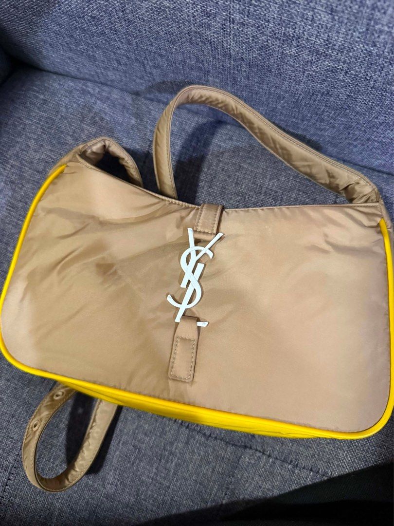 Saint Laurent Paris Nylon Shoulder Bag (Category: Luxury Bags & Wallets) located in Paranaque City. Submitted by piasacramento (Listing ID 1456633648, Image 1). Description: - Authentic Saint Laurent Paris shoulder bag - Tan nylon material with yellow trim - Iconic white YSL logo - Interior zip pocket - Leather patch with Saint Laurent Paris branding - Engraved Saint Laurent Paris zipper pull - Comes with dust bag and authenticity cards.