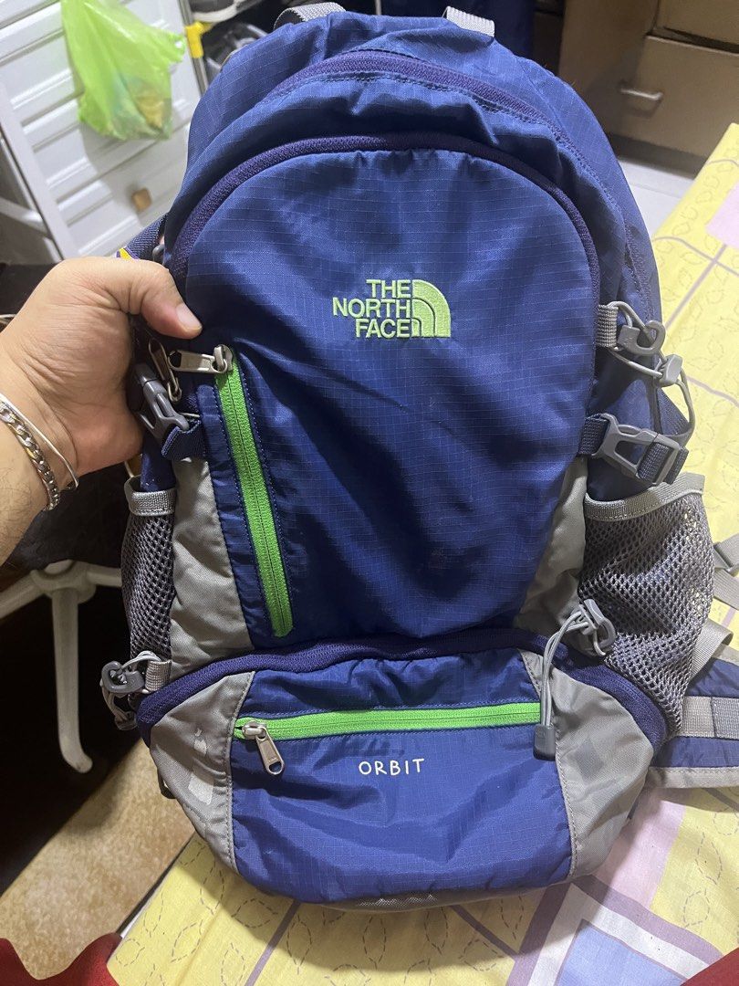 The North Face Orbit Backpack Blue Green (Category: Backpacks) located in Manila. Submitted by jankbaiteh05162 (Listing ID 1456627466, Image 1). Description: - Brand: The North Face - Model: Orbit - Color: Blue with green accents - Features: Multiple pockets, mesh side pockets - Includes: Blue rain cover with The North Face logo - Ideal for: Day trips, hiking.