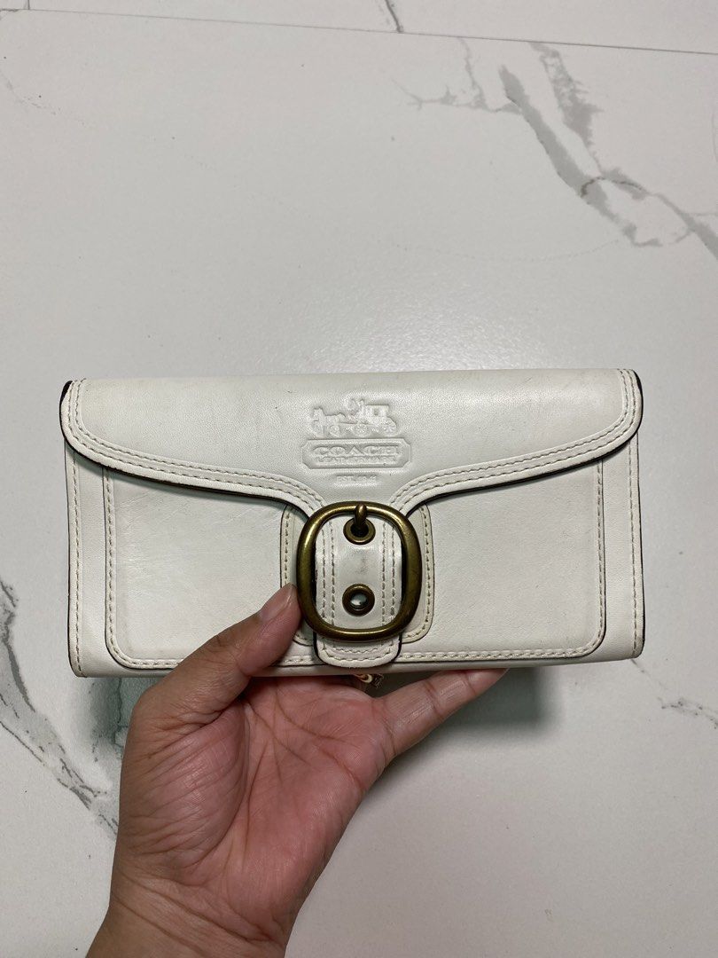 Vintage Coach White Bleecker Leather Trifold (Category: Luxury Bags & Wallets) located in Balagtas. Submitted by dadalalashop (Listing ID 1456614694, Image 2). Description: The white leather Coach Bleeker wallet features a distinctive brass buckle closure and an embossed logo on the front flap..
