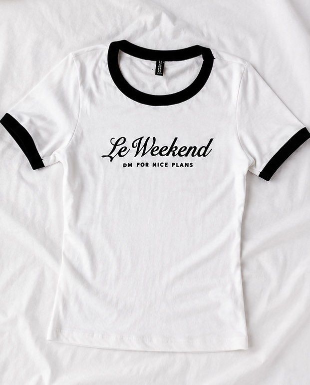 White 'Le Weekend' Ringer Tee (Category: Shirts) located in Las Pinas. Submitted by katb86 (Listing ID 1456685433, Image 1). Description: - Cute white ringer t-shirt - Black trim detail - Front graphic: 'Le Weekend DM FOR NICE PLANS' - Ideal for casual wear - Pairs well with jeans or shorts - Perfect for weekend outfits.