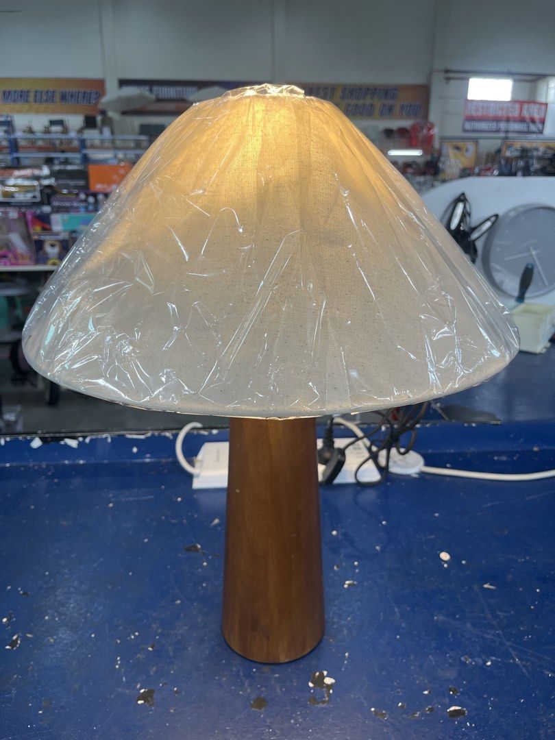 Wooden Base Table Lamp with Fabric Shade (Category: Lighting) located in Caloocan City. Submitted by hmr.gomez (Listing ID 1456609796, Image 1). Description: - Classic table lamp with a warm wooden base. - Neutral fabric shade for a soft, cozy glow. - Simple and elegant design, perfect for bedside tables or desks. - Enhances the ambiance of any room. - Comes complete with a power cord and plug..