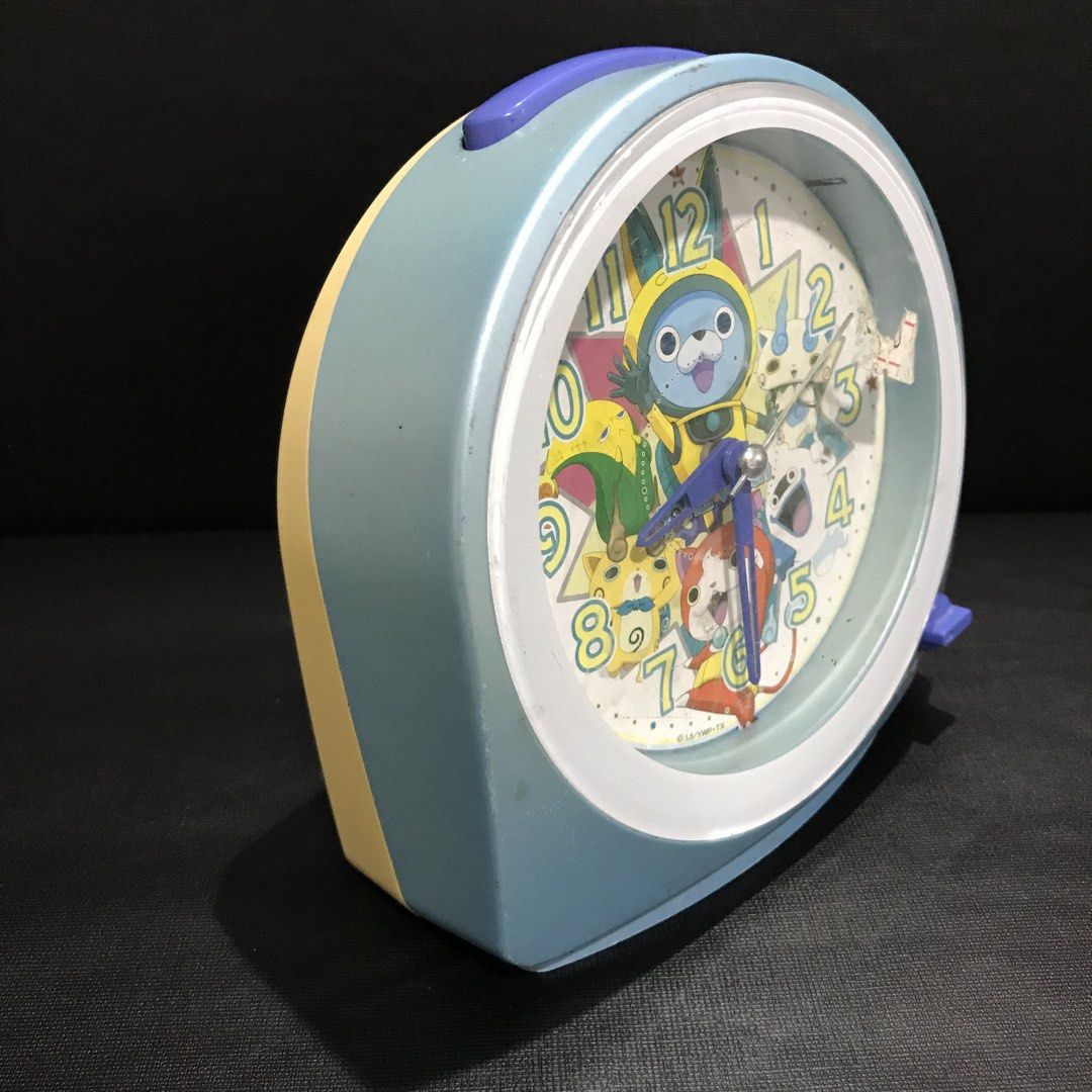 Yo-kai Alarm Clock (Category: Clocks) located in Baao. Submitted by all.things.japan (Listing ID 1456672714, Image 3). Description: - Cute Yo-kai Watch alarm clock - Features characters from the show - Light blue and yellow casing - Alarm on/off switch and snooze button - Battery operated - Perfect for fans or a fun bedside clock.
