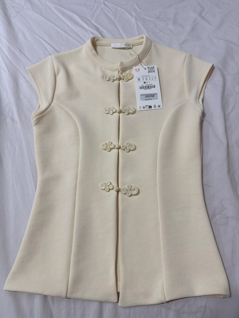 Zara Stretch Top with Frog Fastenings (Category: Blouses) located in Masbate. Submitted by anjcbr (Listing ID 1456604316, Image 1). Description: - Zara Stretch Top with Frog Fastenings - Mandarin collar with traditional frog button closures - Brand new with tag still attached.