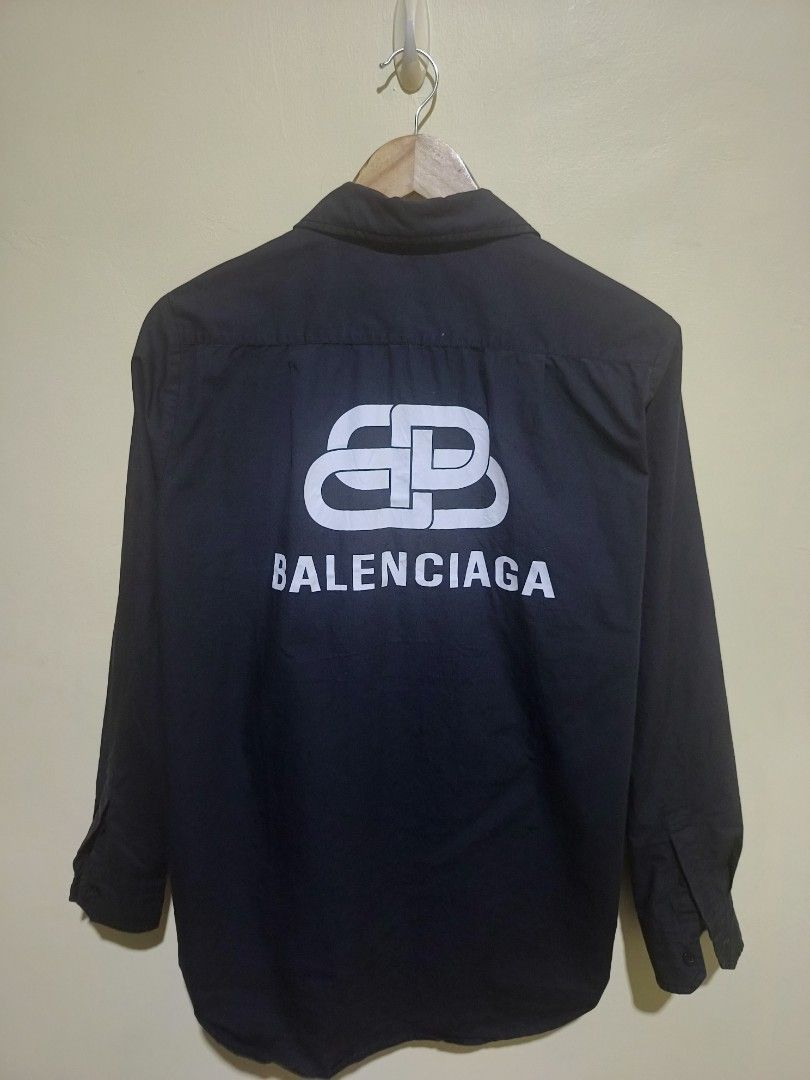Balenciaga Long Sleeve Shirt (Category: Tshirts & Polo Shirts ) located in Angeles City. Submitted by thriftglitz (Listing ID 1456950415, Image 1). Description: Best fit medium No Issue 9.8/10 condition - Authentic Balenciaga black button-up shirt - Features iconic BB logo prominently on the back - Subtle logo patch on the chest pocket - Classic long sleeves with adjustable button cuffs - Perfect for elevating your casual or smart casual look.