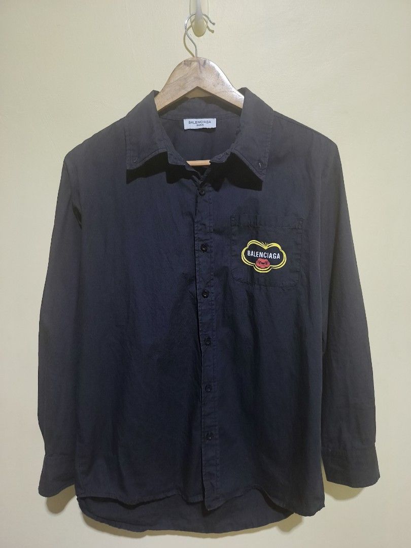 Balenciaga Long Sleeve Shirt (Category: Tshirts & Polo Shirts ) located in Angeles City. Submitted by thriftglitz (Listing ID 1456950415, Image 2). Description: Best fit medium No Issue 9.8/10 condition - Authentic Balenciaga black button-up shirt - Features iconic BB logo prominently on the back - Subtle logo patch on the chest pocket - Classic long sleeves with adjustable button cuffs - Perfect for elevating your casual or smart casual look.
