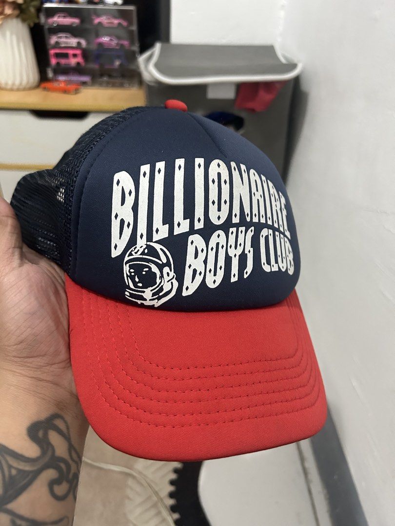Billionaire Boys Club Trucker Cap (Category: Caps & Hats) located in Manila. Submitted by talaskidoo (Listing ID 1456901627, Image 2). Description: - Classic Billionaire Boys Club trucker cap - Features iconic astronaut logo and bold lettering - Navy blue and red colorway - Breathable mesh back - Adjustable strap for a custom fit - Ideal for any streetwear enthusiast.