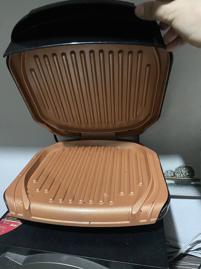 Black Electric Grill Pan with Copper Plates (Category: Cookware & Accessories) located in Marikina City. Submitted by ffm73 (Listing ID 1456912294, Image 2). Description: - Versatile electric grill pan for indoor cooking. - Elegant black exterior. - High-quality copper-colored grill plates. - Lid features metallic accents and red/green indicator lights. - Includes a decorative white ceramic tray with a blue floral design..