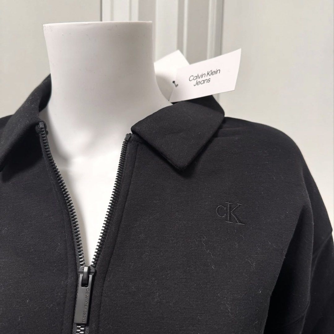 Calvin Klein Jeans Black Half Zip Collar Sweatshirt (Category: Coats, Jackets and Outerwear) located in Tarlac. Submitted by mkc27 (Listing ID 1456861144, Image 2). Description: - Black Calvin Klein Jeans sweatshirt - Features a half zip collar - Embroidered CK logo on the chest - Long sleeves with ribbed cuffs and hem - Cropped fit - Ideal for casual wear.