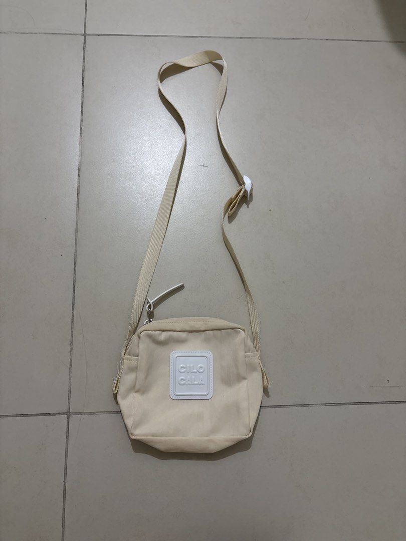 CILO CALA Beige Canvas Crossbody Bag (Category: Cross-body Bags) located in Pasig City. Submitted by dianexing (Listing ID 1456833786, Image 1). Description: - Beige canvas crossbody bag from CILO CALA - Adjustable strap with buckle - Small front pocket - Zipper closure - Ideal for everyday use - Fits phone, wallet, and keys.