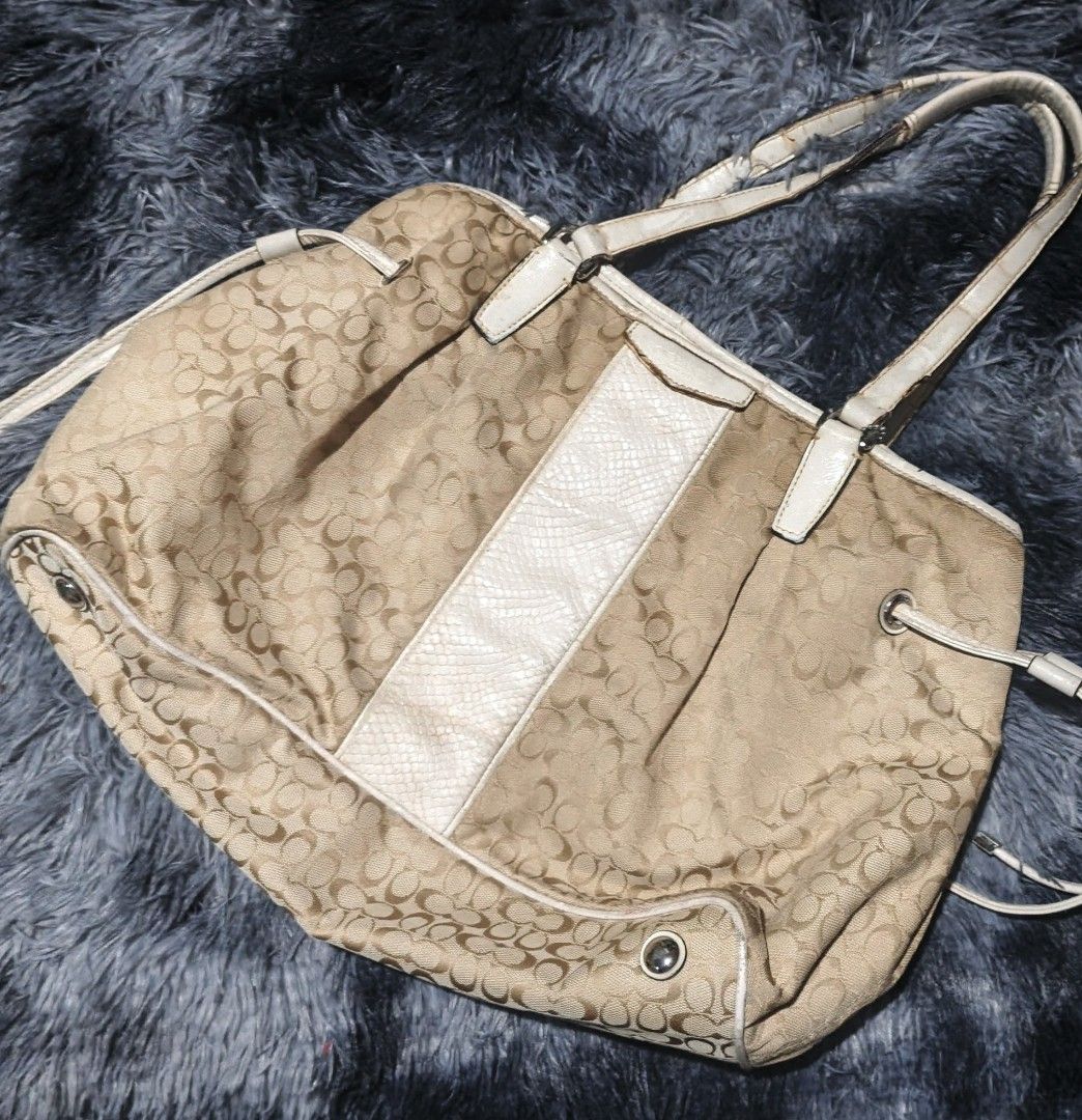 Coach Monogram Canvas & Leather Trim Tote Bag (Category: Luxury Bags & Wallets) located in Butuan. Submitted by luxestreet04 (Listing ID 1456825384, Image 1). Description: - Authentic Coach tote bag - Beige and brown monogram canvas - White leather trim with snakeskin accent stripe - Drawstring sides - Interior zippered pocket - Some signs of wear on leather trim and handles - Clean interior - Ideal for everyday use.