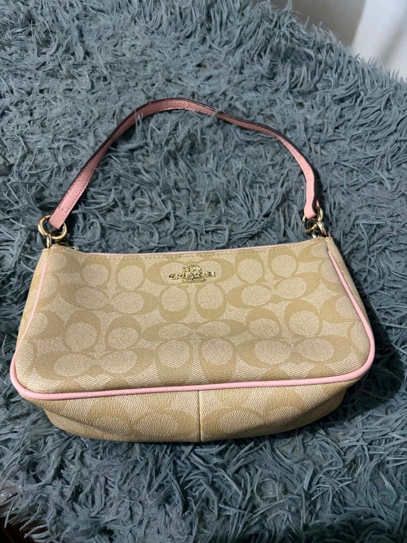 Coach Monogram Wristlet Pouch with Pink Trim (Category: Luxury Bags & Wallets) located in Daraga. Submitted by argarinang25024 (Listing ID 1456814257, Image 1). Description: -Coach wristlet pouch - Classic monogram print - Chic pink trim and strap - Secure zipper closure - Interior with pink lining - Gold hardware details - Ideal for carrying your daily essentials - No issue.