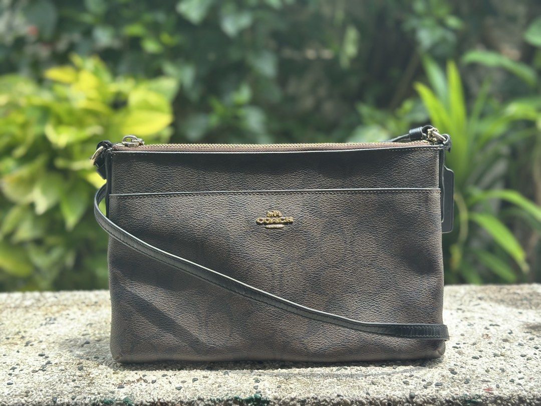 Coach purse (Category: Luxury Bags & Wallets) located in Pasig City. Submitted by lancer501 (Listing ID 1456814294, Image 1). Description: - Brand: Coach - Type: Vanity Bag - Color: Brown signature pattern - Condition: Great, pre-loved - Features: Compact and stylish design - Perfect for everyday use -Comes with coach envelope addon -creed is damaged by age -Shipping shouldered by buyer.