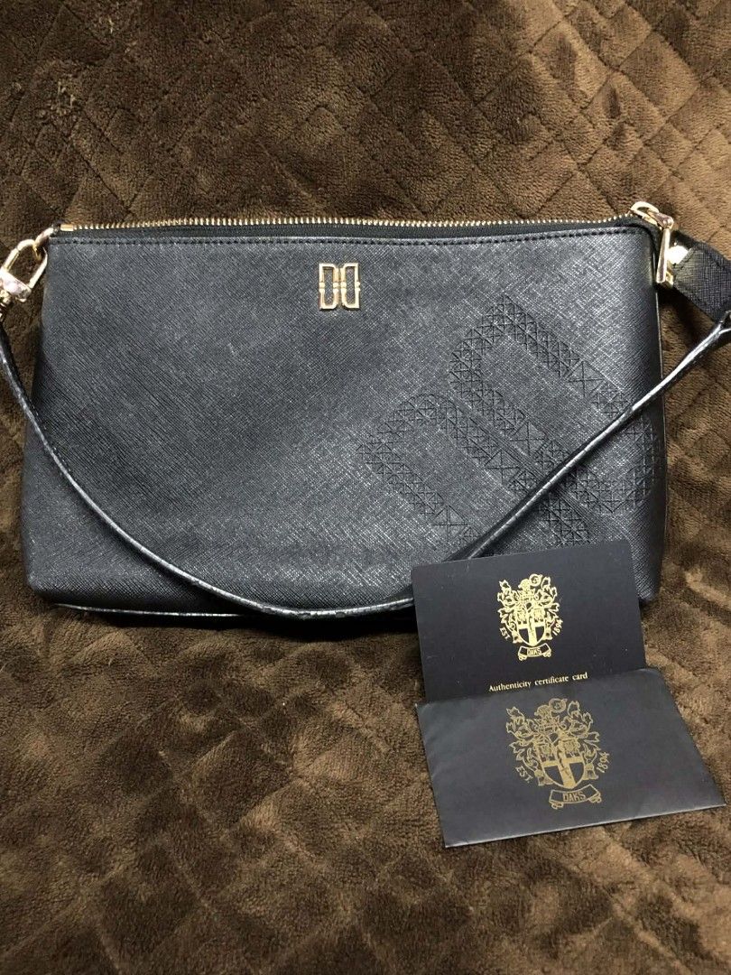 DAKS Black Leather Clutch Bag with Authenticity Card (Category: Luxury Bags & Wallets) located in Caloocan City. Submitted by jennielz (Listing ID 1456812993, Image 1). Description: - Genuine DAKS black leather clutch - Subtle embossed pattern on the front - Includes original authenticity -has minor flaws in rubber linings -no issues sa body -with certificate card - Secure gold zipper closure - Ideal for evening events or as a travel pouch.