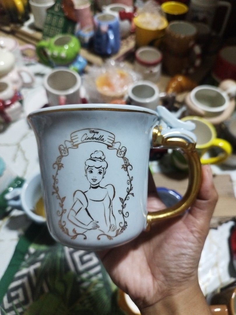 Disney Cinderella Zak! Mug with Gold Handle (Category: Coffee & Tea Tableware) located in Manila. Submitted by silverwhale_cafa21 (Listing ID 1456874085, Image 1). Description: - Light blue mug featuring Cinderella and her mice friends - Elegant gold handle - Made by Zak! Designs - Ideal for Disney fans and collectors - Perfect for coffee or tea - Dishwasher and microwave safe.