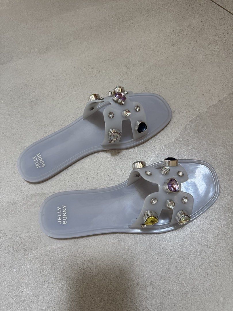 Embellished Jelly Sandals (Category: Flats & Sandals) located in Taguig. Submitted by agclim (Listing ID 1456807375, Image 1). Description: - Grey Jelly Bunny jelly sandals - Decorated with sparkly gems and silver accents - Easy slip-on style - Sole measures approximately 10 inches long - Ideal for casual wear or beach days.