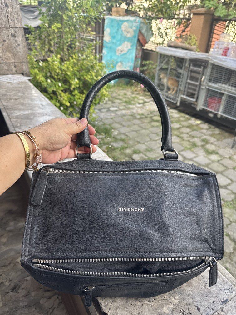 Givenchy Black Leather Nightingale Handbag (Category: Camera Bags & Carriers) located in Angeles City. Submitted by migs_font29 (Listing ID 1456947278, Image 1). Description: - Authentic black leather Givenchy Nightingale bag - Iconic and versatile design - Features both top handles and a detachable shoulder strap - Ample interior space for daily essentials - Smooth and fully functional zippers - A timeless and stylish accessory for any fashion-c