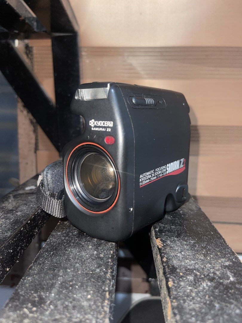Kyocera Samurai Z2 Automatic Focusing Zoom Lens Camera (Category: Cameras) located in Manila. Submitted by polavoid (Listing ID 1456881054, Image 1). Description: Kyocera Samurai Z2 camera. Automatic focusing zoom lens. A half frame camera that has a Lens is f=25mm-75mm 1:4.0-5.6. And a grip strap. Great for capturing memories. Fully working, zoom and flash, tested with spare batteries (NOT INCLUDED) but no film to test it with, but everything wo