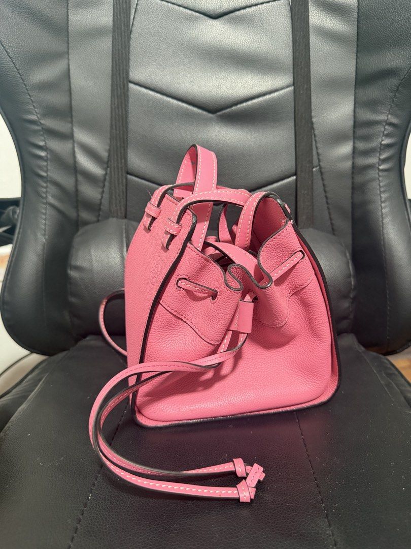 Loewe Pink Leather Mini Bucket Bag (Category: Luxury Bags & Wallets) located in Antipolo. Submitted by declutteringirlie0317 (Listing ID 1456933985, Image 1). Description: - Pink leather mini bucket bag - Drawstring closure - Top handles and a long strap - Embossed Loewe logo on the front - Compact and perfect for carrying essentials.