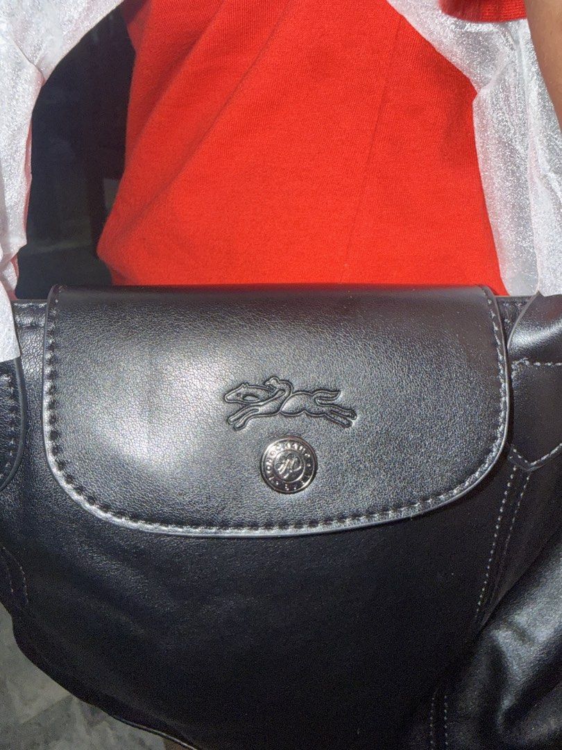 Longchamp Black Leather Shoulder Bag (Category: Carriers & Slings) located in Angeles City. Submitted by migs_font29 (Listing ID 1456908314, Image 2). Description: - Authentic Longchamp black leather shoulder bag - Features iconic horse logo on the front flap - Adjustable shoulder strap with embossed Longchamp lettering - Secure top zipper closure - Clean and spacious interior - Ideal for everyday wear and tear.