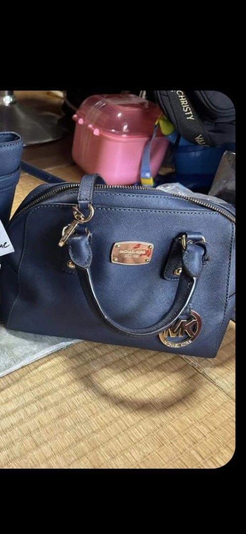 Michael Kors Navy Blue Leather Satchel Handbag (Category: Luxury Bags & Wallets) located in Quezon City. Submitted by melmgpy (Listing ID 1456825843, Image 2). Description: - Michael Kors navy blue leather satchel - Gold tone hardware - Signature MK logo charm - Top handles - Detachable shoulder strap - Spacious interior for essentials - Ideal for everyday use.