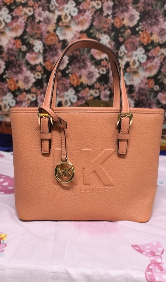Michael Kors Tote Bag - Coral Pink (Category: Luxury Bags & Wallets) located in Malabon City. Submitted by cfmalubs (Listing ID 1456785452, Image 3). Description: - Authentic Michael Kors tote bag in a vibrant coral pink. - Crafted from durable pebbled leather. - Elegant gold hardware details and embossed MK logo on the front. - Convenient top handles for easy carrying. - Compact, small size ideal for daily essentials. - Interior and exterior are
