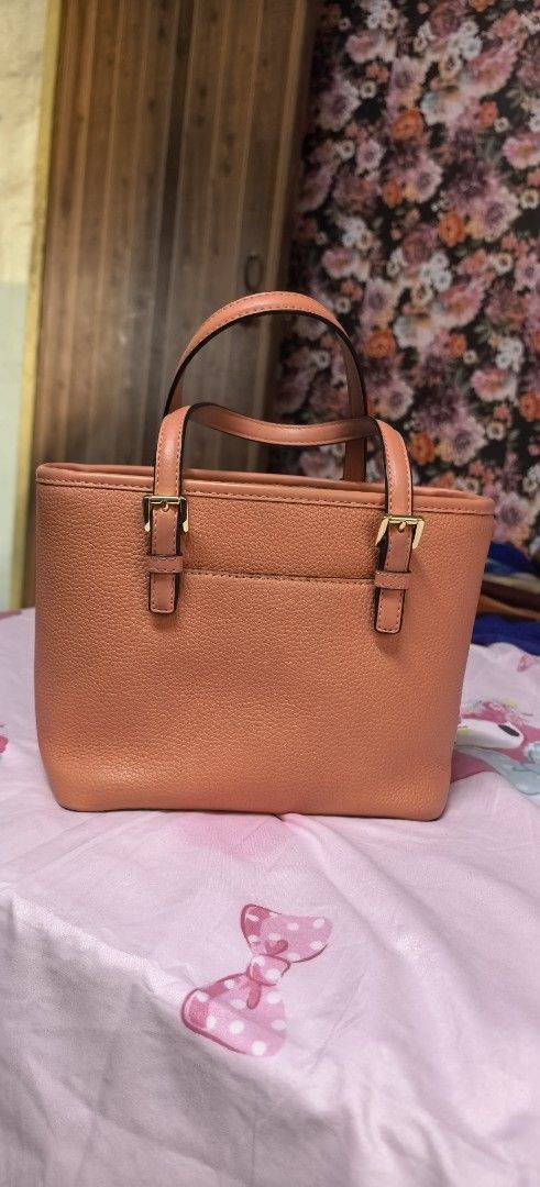 Michael Kors Tote Bag - Coral Pink (Category: Luxury Bags & Wallets) located in Malabon City. Submitted by cfmalubs (Listing ID 1456785452, Image 2). Description: - Authentic Michael Kors tote bag in a vibrant coral pink. - Crafted from durable pebbled leather. - Elegant gold hardware details and embossed MK logo on the front. - Convenient top handles for easy carrying. - Compact, small size ideal for daily essentials. - Interior and exterior are