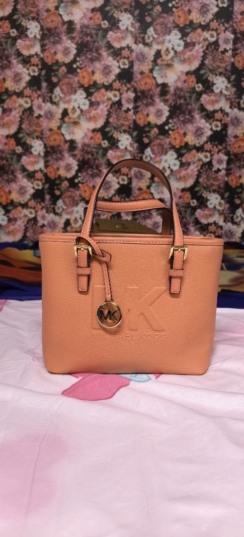Michael Kors Tote Bag - Coral Pink (Category: Luxury Bags & Wallets) located in Malabon City. Submitted by cfmalubs (Listing ID 1456785452, Image 1). Description: - Authentic Michael Kors tote bag in a vibrant coral pink. - Crafted from durable pebbled leather. - Elegant gold hardware details and embossed MK logo on the front. - Convenient top handles for easy carrying. - Compact, small size ideal for daily essentials. - Interior and exterior are