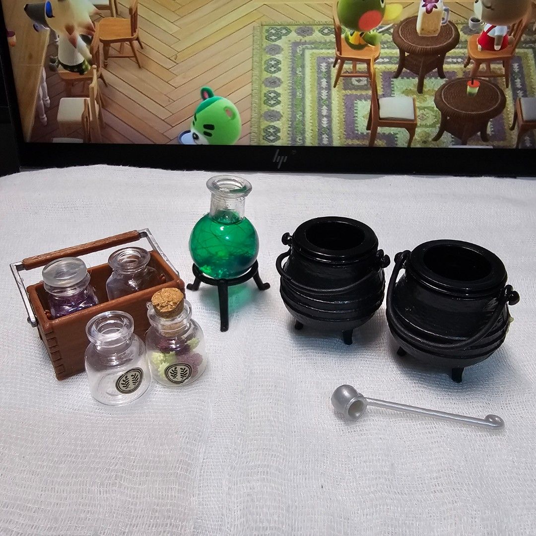 Miniverse Miniature Witch Cauldrons, Potion Bottles, and Stand (Category: Figurines & Statues) located in Rizal. Submitted by viviperera (Listing ID 1456900890, Image 1). Description: 3 sets available with glue stain at the back wysiwyg - Cute miniature set for dollhouse. - Includes 2 black cauldrons. - Features a green potion bottle on a stand. - Comes with a wooden rack holding 4 small potion bottles. - Rack bottles have cork stoppers and color