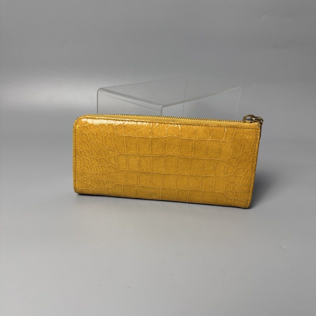 Miu miu crocodile long wallet (Category: Luxury Bags & Wallets) located in Malasiqui. Submitted by fosh0fosh0 (Listing ID 1456925888, Image 2). Description: - Brand: Miu Miu - Type: Long Wallet - Color: Mustard Yellow - Material: Crocodile embossed leather - Design: Zip-around closure, spacious interior - Condition: Excellent, well-maintained - Style: Luxury, statement piece.