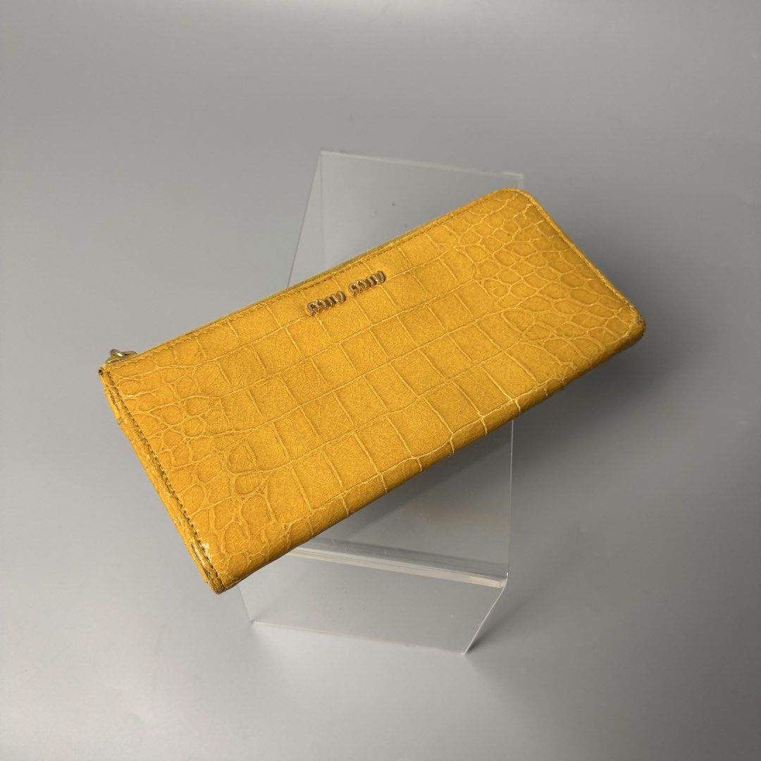 Miu miu crocodile long wallet (Category: Luxury Bags & Wallets) located in Malasiqui. Submitted by fosh0fosh0 (Listing ID 1456925888, Image 3). Description: - Brand: Miu Miu - Type: Long Wallet - Color: Mustard Yellow - Material: Crocodile embossed leather - Design: Zip-around closure, spacious interior - Condition: Excellent, well-maintained - Style: Luxury, statement piece.