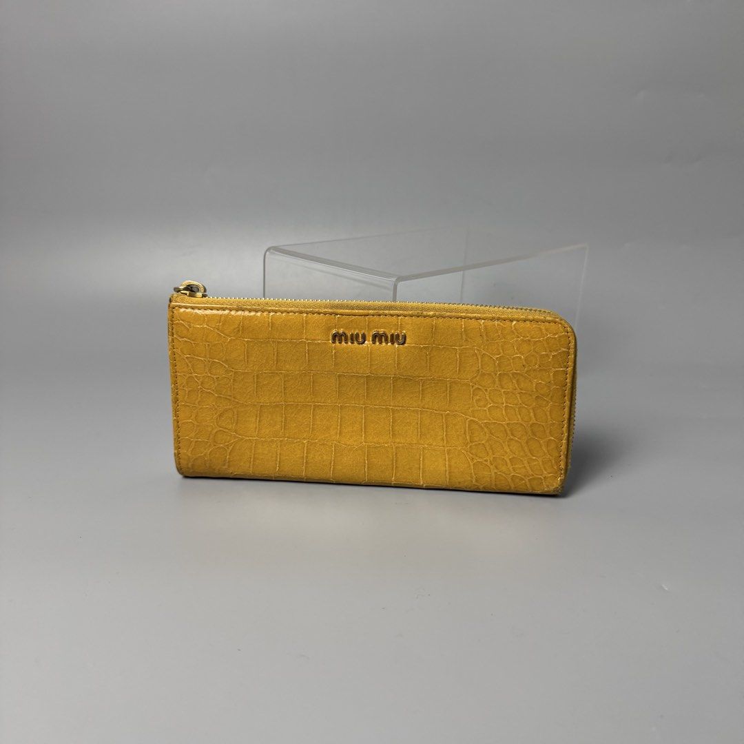 Miu miu crocodile long wallet (Category: Luxury Bags & Wallets) located in Malasiqui. Submitted by fosh0fosh0 (Listing ID 1456925888, Image 1). Description: - Brand: Miu Miu - Type: Long Wallet - Color: Mustard Yellow - Material: Crocodile embossed leather - Design: Zip-around closure, spacious interior - Condition: Excellent, well-maintained - Style: Luxury, statement piece.