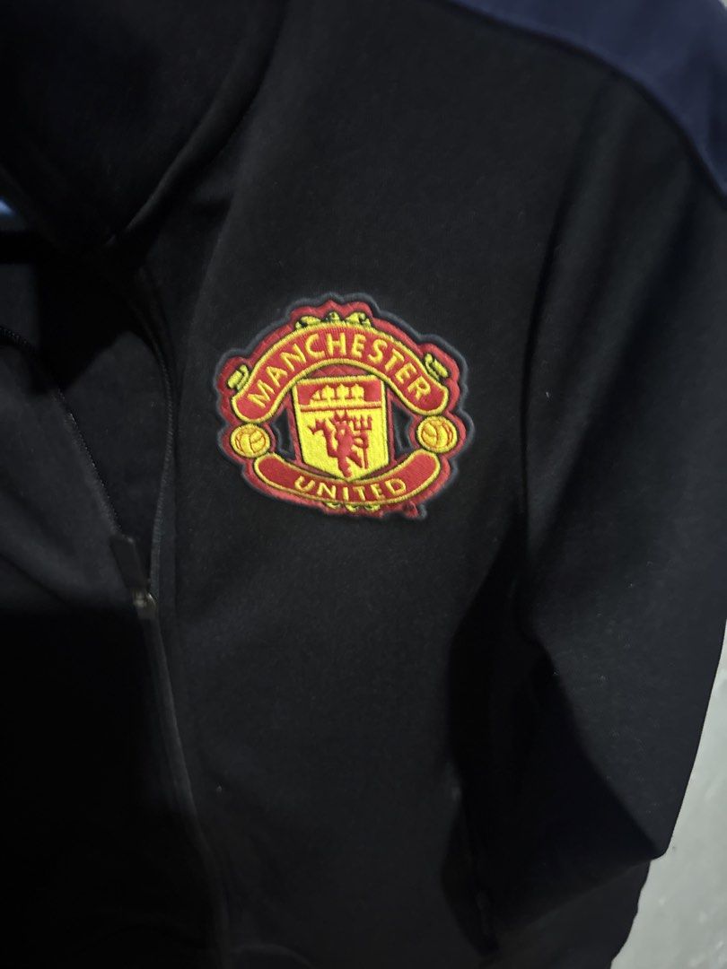 Nike Manchester United Track Jacket (Category: Fragrance & Deodorants) located in Angeles City. Submitted by migs_font29 (Listing ID 1456821028, Image 2). Description: - Official Nike Manchester United track jacket - Color: Black - Features the Manchester United crest on the chest - 'Manchester United' text printed on the back - Size: 137-147cm (suitable for 10-12 years old) - Made in China.