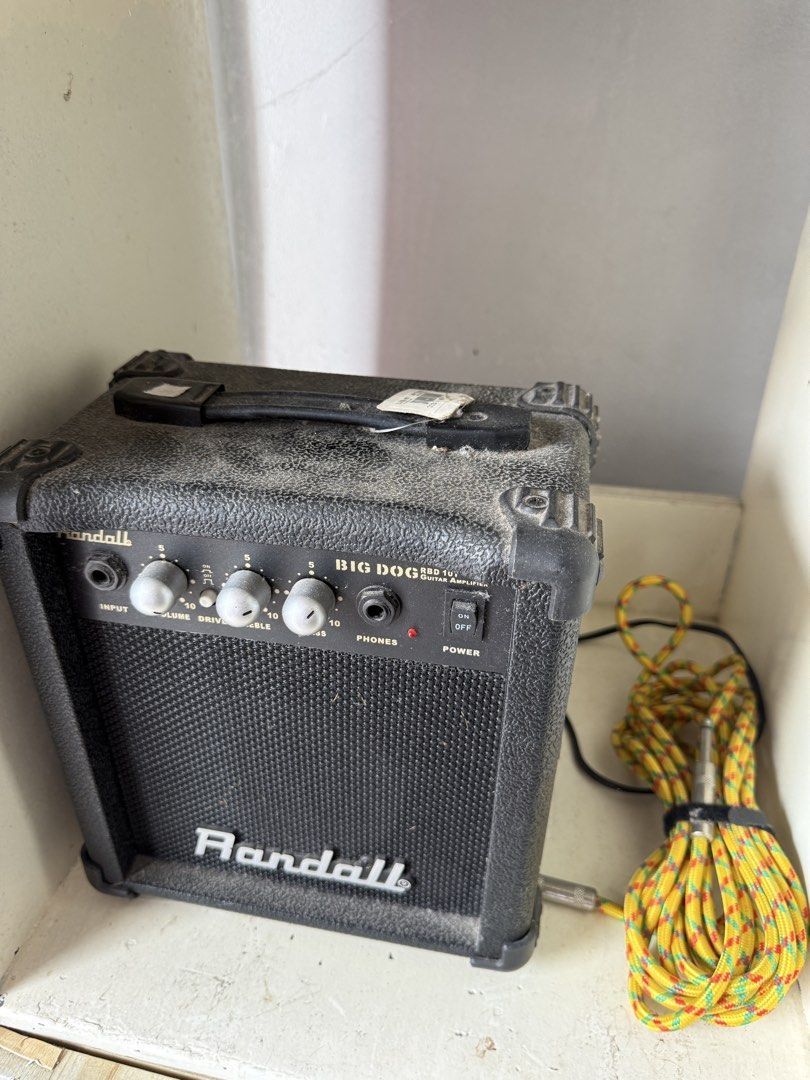 Randall Big Dog RBD 10 Guitar Amplifier with Cable (Category: Musical Instruments) located in Manila. Submitted by snoopydo (Listing ID 1456823711, Image 1). Description: - Randall Big Dog RBD 10 guitar amplifier - Controls: Volume, Drive, Tone - Headphone jack included - Comes with a yellow and red patterned cable - Ideal for practice sessions or small gigs.