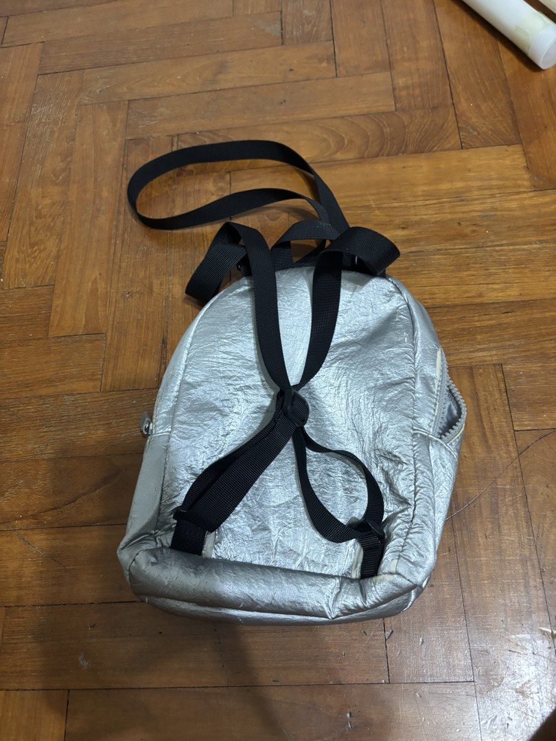 Silver Mini Backpack (Category: Backpacks) located in Singapore. Submitted by marie.cbs (Listing ID 1456933945, Image 2). Description: - Cute silver mini backpack - Front zip pocket and main compartment - Adjustable straps - Ideal for essentials - Minor signs of wear on front zipper area.
