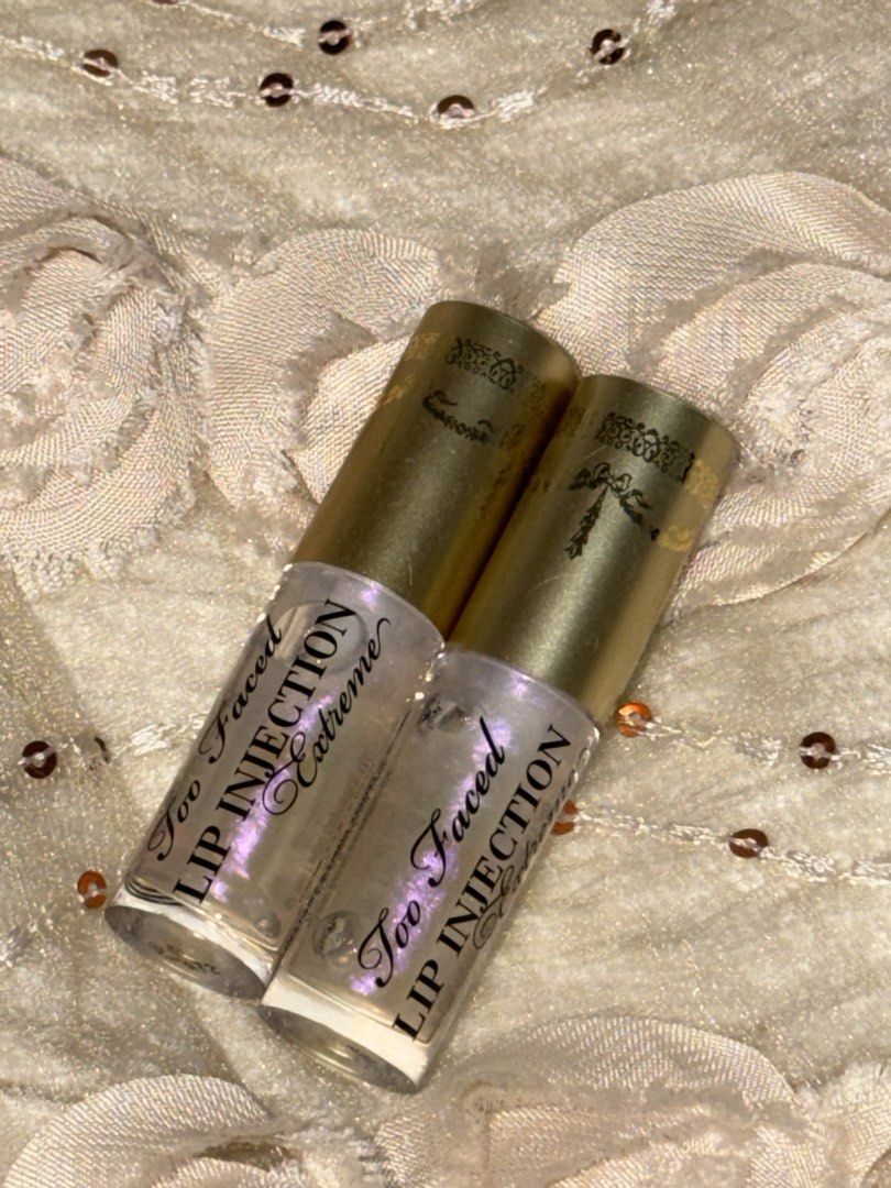 Too Faced Lip Injection Extreme Gloss Duo (Category: Makeup) located in Quezon City. Submitted by rhai_decluttering (Listing ID 1456895224, Image 1). Description: - Two Too Faced Lip Injection Extreme glosses included. - Features elegant gold caps with intricate designs. - Clear tubes showcase the shimmering, pearlescent gloss. - Designed to add volume and shine for visibly plumper lips. - Perfect for achieving a fuller, more luscious pout. Take 