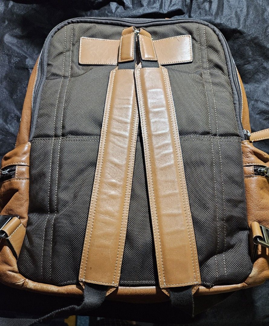 Tumi Leather and Canvas Backpack (Category: Luxury Bags & Wallets) located in Valenzuela. Submitted by _myperfectstuff (Listing ID 1456863514, Image 2). Description: - Durable brown leather and dark grey canvas construction - Multiple zippered compartments on the front for easy access - Padded shoulder straps for maximum comfort during wear - Convenient side pockets for water bottles or small essentials - Ideal for daily commutes, school, or trav
