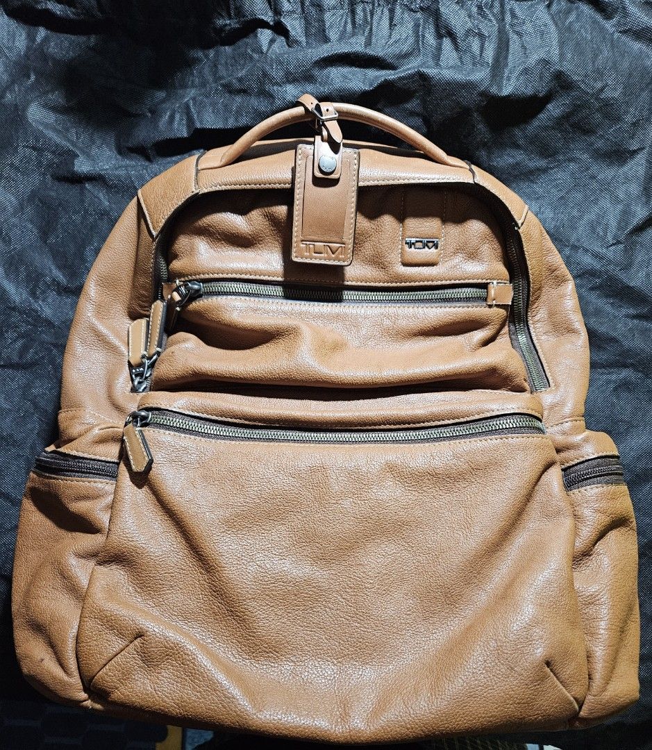 Tumi Leather and Canvas Backpack (Category: Luxury Bags & Wallets) located in Valenzuela. Submitted by _myperfectstuff (Listing ID 1456863514, Image 1). Description: - Durable brown leather and dark grey canvas construction - Multiple zippered compartments on the front for easy access - Padded shoulder straps for maximum comfort during wear - Convenient side pockets for water bottles or small essentials - Ideal for daily commutes, school, or trav