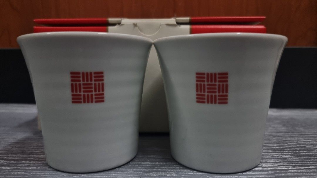 Uniqlo Ceramic Cups Set of 2 (Category: Coffee & Tea Tableware) located in Manila. Submitted by themvi (Listing ID 1456851236, Image 1). Description: - Set of 2 Uniqlo ceramic cups - Classic white with iconic red square logo - Includes original red gift box with Japanese text - Ideal for enjoying your favorite tea or coffee - Makes a thoughtful gift idea.