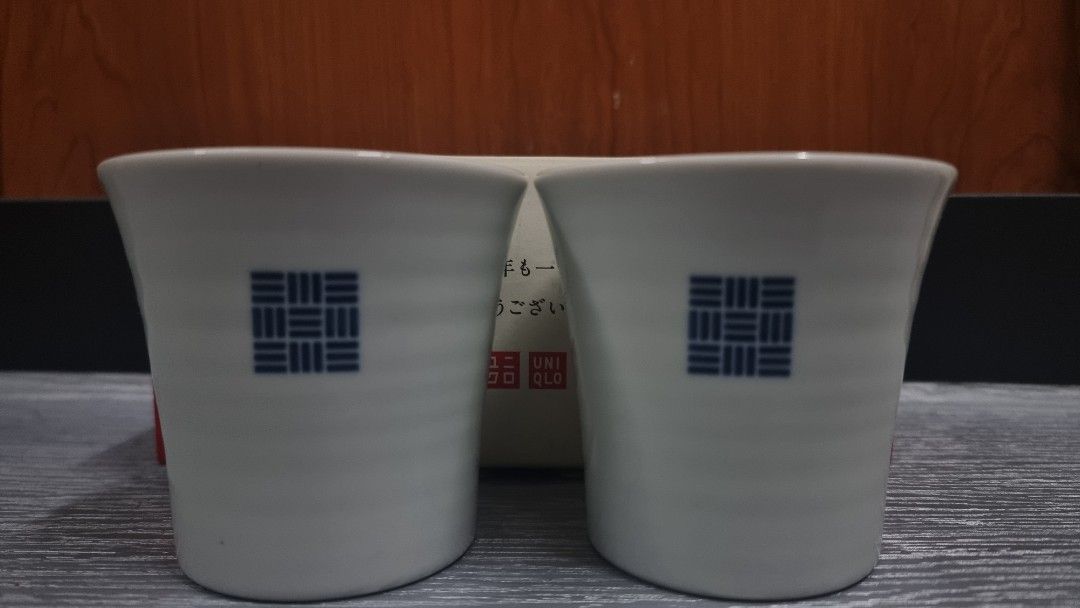 Uniqlo Ceramic Cups Set of 2 (Category: Coffee & Tea Tableware) located in Manila. Submitted by themvi (Listing ID 1456851336, Image 1). Description: - Set of 2 Uniqlo ceramic cups - White with a classic blue grid design - Comes in original red box with Japanese text - Perfect for enjoying tea or coffee - Great gift idea or for personal collection.